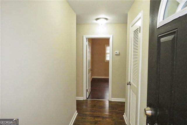 hall featuring baseboards and wood finished floors