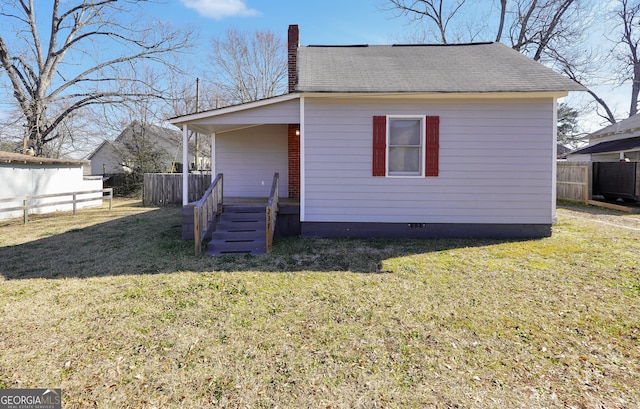 view of front facade featuring crawl space, a chimney, a front lawn, and fence