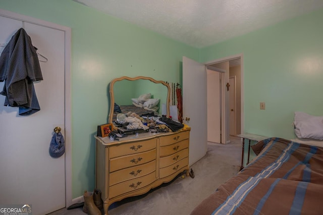 bedroom with light colored carpet and a textured ceiling