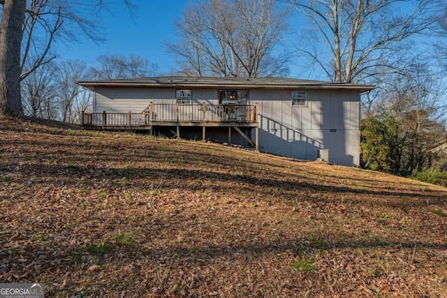 rear view of house featuring a deck, stairway, and board and batten siding