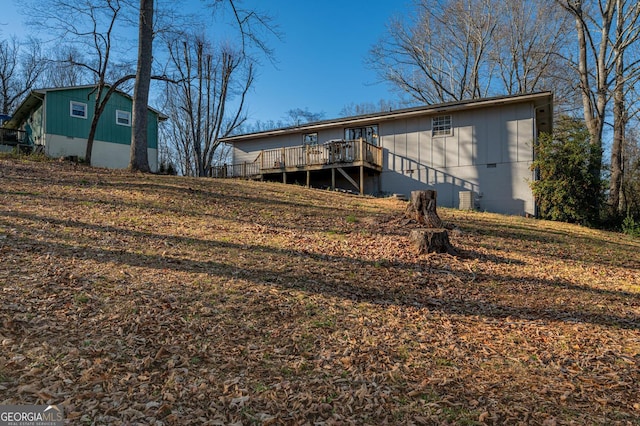 back of house featuring crawl space and a deck