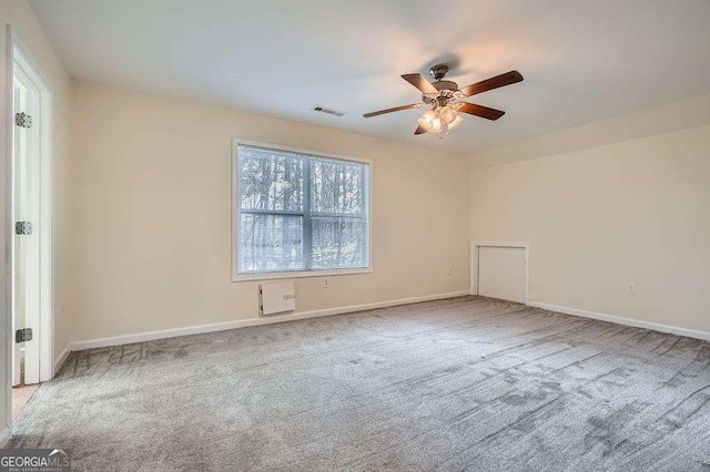 carpeted empty room with visible vents, a ceiling fan, and baseboards