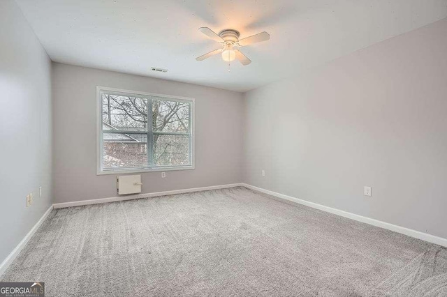 empty room featuring carpet flooring, baseboards, and visible vents