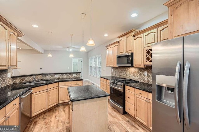 kitchen with light wood finished floors, tasteful backsplash, light brown cabinets, appliances with stainless steel finishes, and a sink