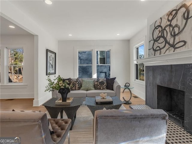 living room featuring recessed lighting, baseboards, wood finished floors, and a fireplace