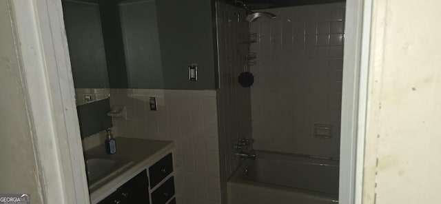 full bath featuring shower / bathing tub combination, tile walls, a wainscoted wall, and vanity