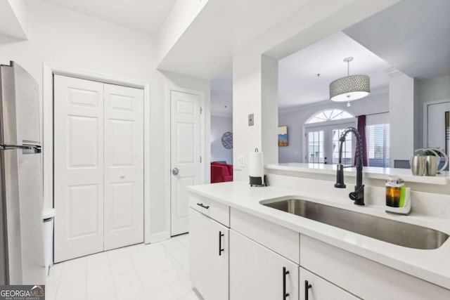 kitchen featuring a sink, decorative light fixtures, white cabinetry, french doors, and light countertops