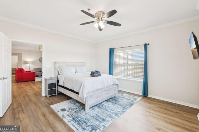 bedroom featuring crown molding, baseboards, and wood finished floors