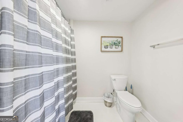 bathroom with tile patterned floors, baseboards, and toilet