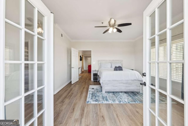 bedroom with french doors, wood finished floors, baseboards, and ornamental molding