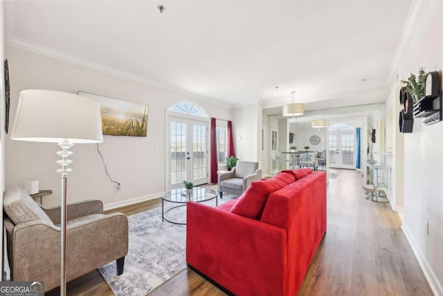 living area featuring french doors, crown molding, and wood finished floors