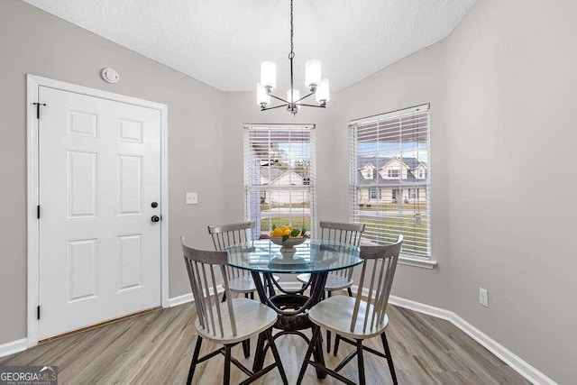 dining room with light wood-style flooring, a healthy amount of sunlight, and baseboards