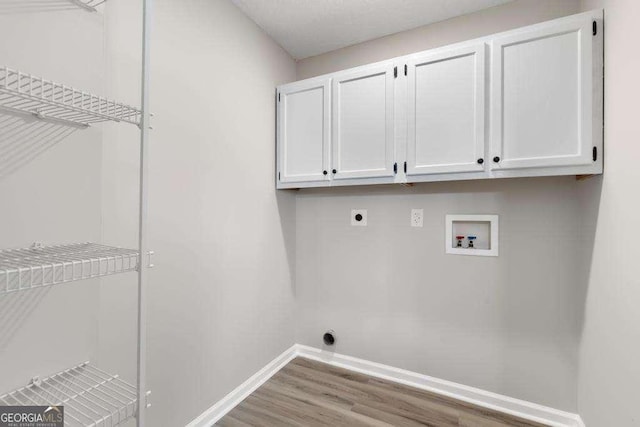 laundry room with electric dryer hookup, wood finished floors, cabinet space, baseboards, and hookup for a washing machine