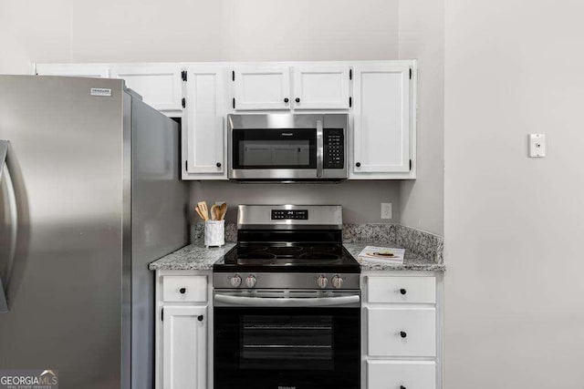 kitchen with white cabinets, stainless steel appliances, and light stone countertops