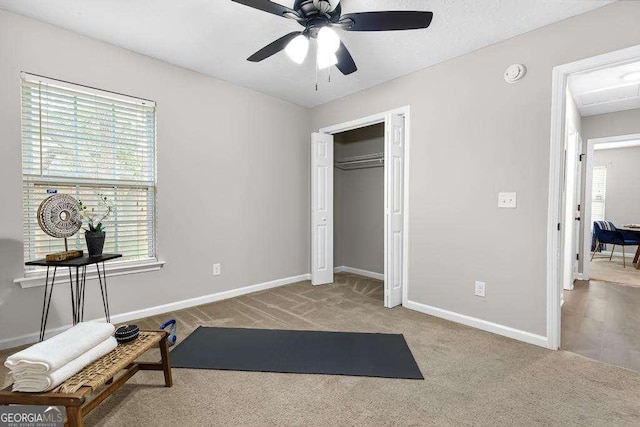 workout area with ceiling fan, baseboards, and carpet