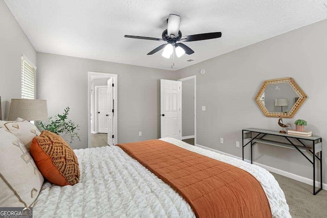 bedroom with a textured ceiling, a ceiling fan, baseboards, and carpet floors