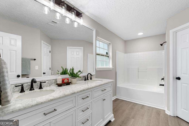 bathroom with double vanity, visible vents, wood finished floors, and a sink