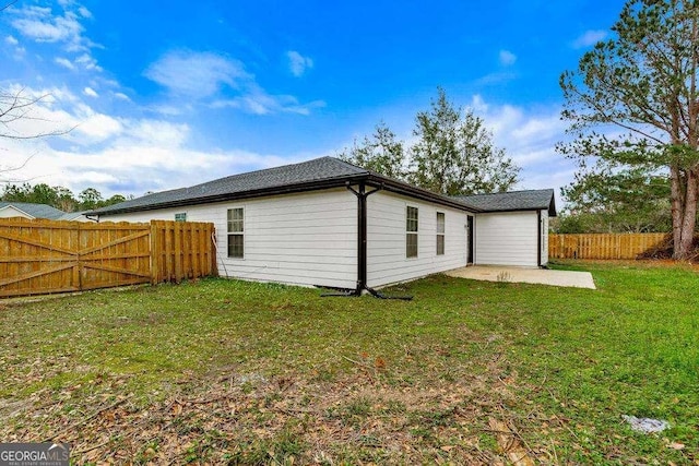 back of house with a patio, a yard, and a fenced backyard