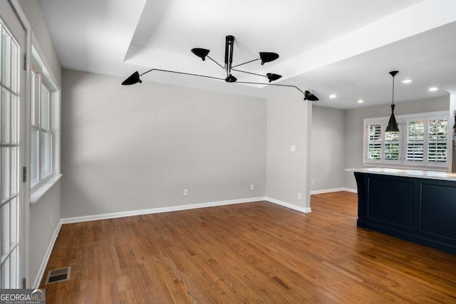 unfurnished living room with recessed lighting, visible vents, baseboards, and wood finished floors