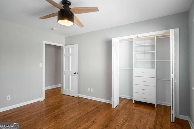 unfurnished bedroom featuring a closet, baseboards, wood finished floors, and a ceiling fan