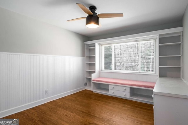 unfurnished office with visible vents, wainscoting, a ceiling fan, and wood finished floors