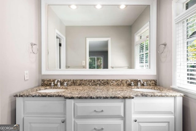 bathroom featuring a sink, recessed lighting, and double vanity