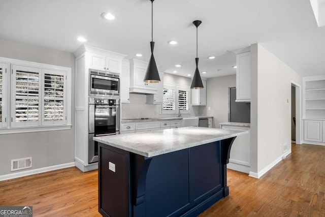 kitchen with visible vents, light wood-style flooring, white cabinets, appliances with stainless steel finishes, and tasteful backsplash