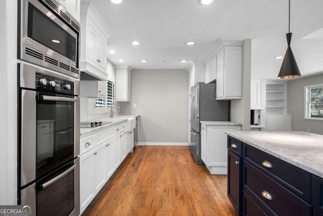 kitchen featuring white cabinets, recessed lighting, light stone countertops, and appliances with stainless steel finishes