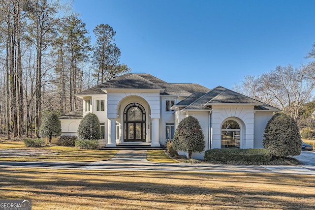 french country style house featuring stucco siding and roof with shingles