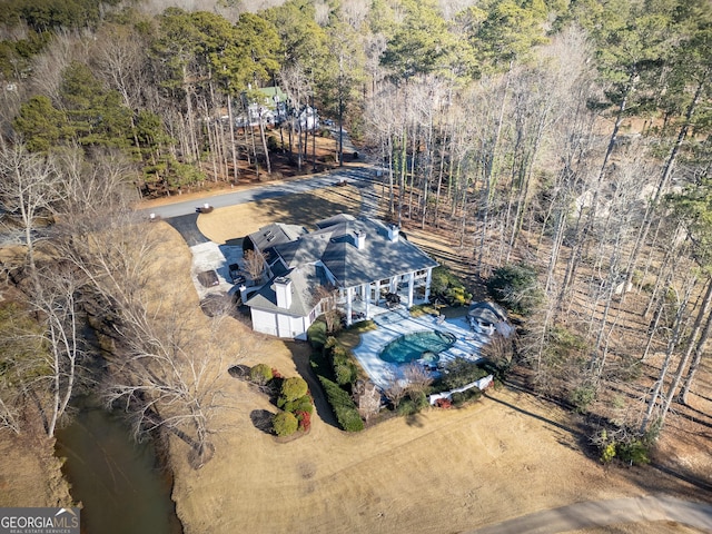 bird's eye view with a wooded view