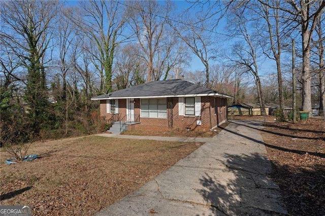 view of front facade with brick siding, driveway, and crawl space