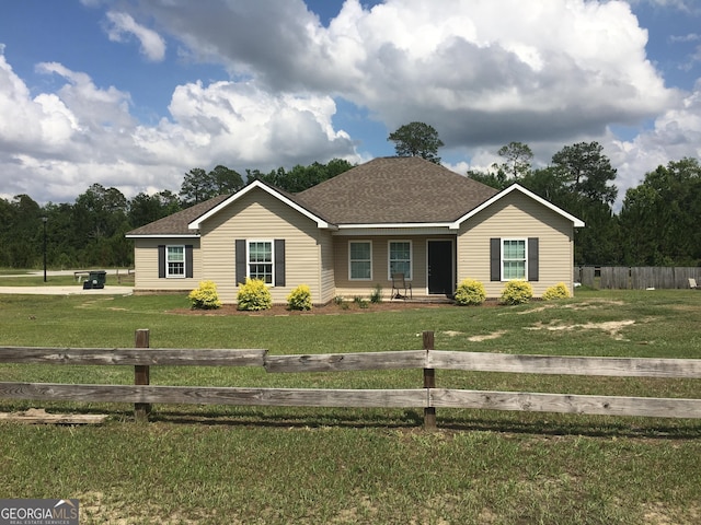 ranch-style home with a front lawn, a fenced front yard, and a shingled roof