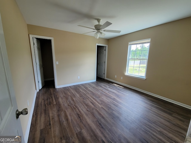 unfurnished bedroom featuring dark wood-type flooring, baseboards, and ceiling fan