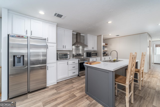 4159 Folks Dr, Blackshear, GA 31516 - kitchen with visible vents, a sink, stainless steel appliances, wall chimney exhaust hood, and white cabinets