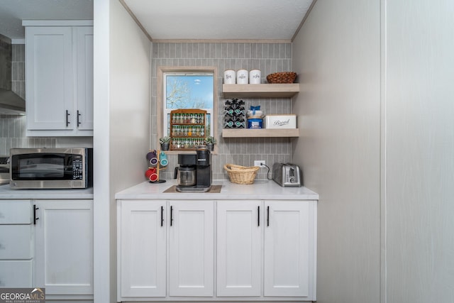 4159 Folks Dr, Blackshear, GA 31516 - bar featuring stainless steel microwave, ornamental molding, exhaust hood, and decorative backsplash