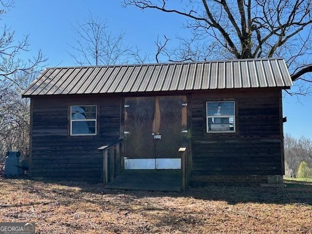 view of property exterior with an outbuilding and metal roof