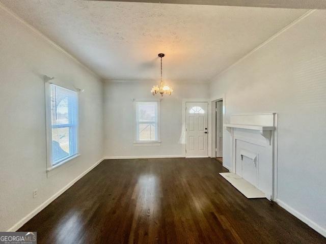 unfurnished dining area featuring dark wood finished floors, plenty of natural light, baseboards, and a chandelier