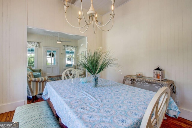 dining room featuring ceiling fan with notable chandelier and wood finished floors