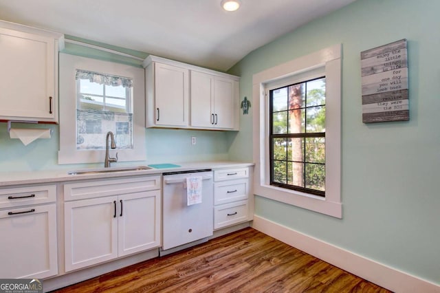 kitchen featuring white cabinetry, light countertops, white dishwasher, and a sink