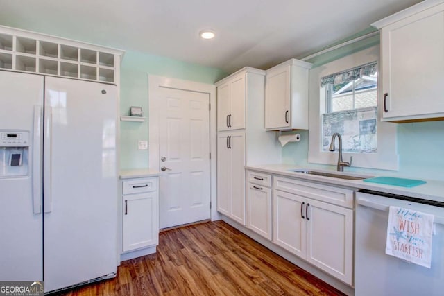 kitchen featuring light countertops, dishwashing machine, white fridge with ice dispenser, white cabinetry, and a sink