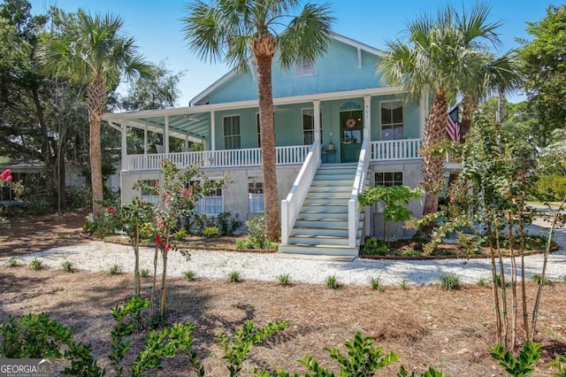 view of front of house featuring stairs, a porch, and stucco siding