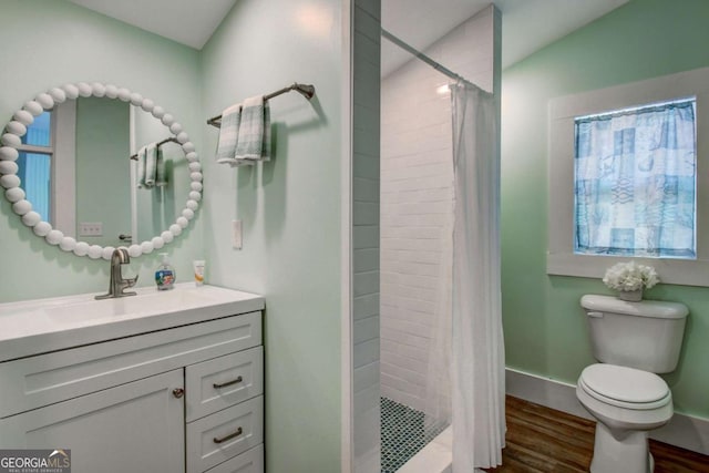 bathroom with toilet, wood finished floors, a shower stall, baseboards, and vanity