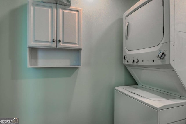 laundry area featuring cabinet space and stacked washer and dryer