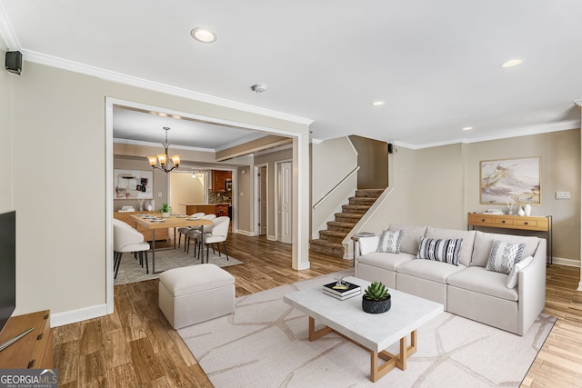 living area with stairway, wood finished floors, recessed lighting, ornamental molding, and a chandelier