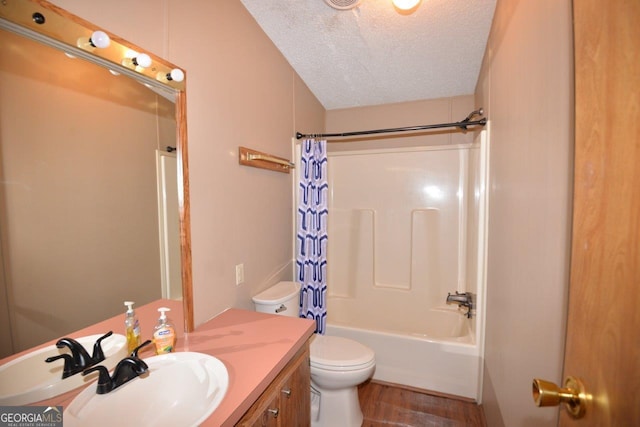 bathroom with vanity, wood finished floors, shower / bath combination with curtain, a textured ceiling, and toilet