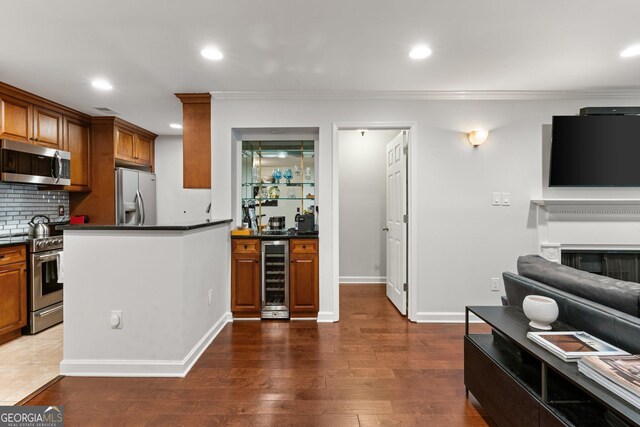 3203 Lenox Rd NE Unit 1, Atlanta, GA 30324 - kitchen with brown cabinetry, beverage cooler, stainless steel appliances, dark countertops, and backsplash