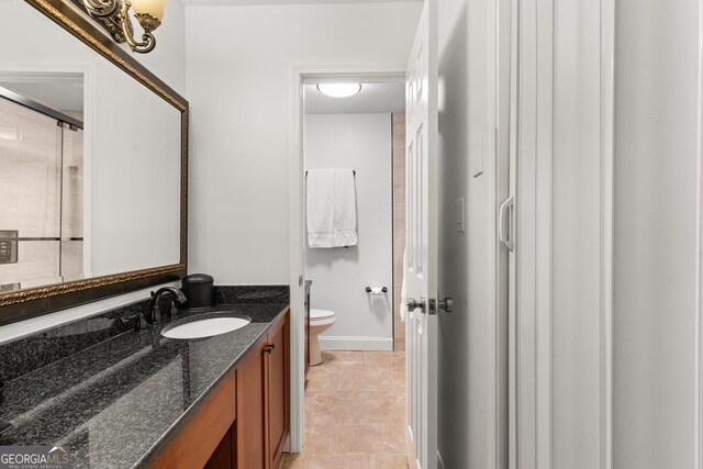 3203 Lenox Rd NE Unit 1, Atlanta, GA 30324 - full bathroom featuring vanity, baseboards, tile patterned flooring, an enclosed shower, and toilet