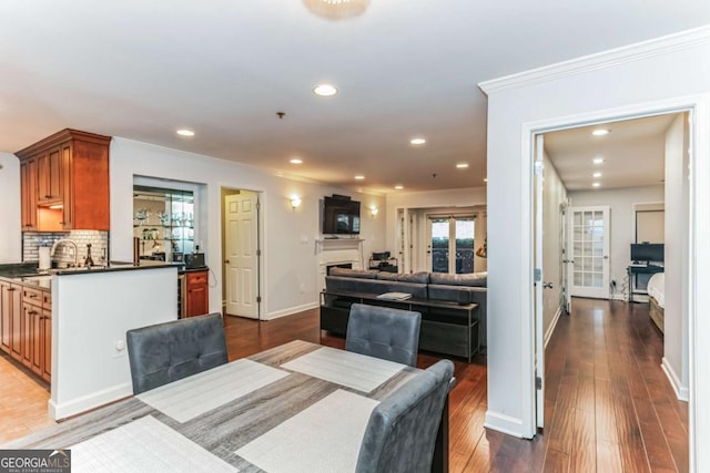 dining space with ornamental molding, wood finished floors, recessed lighting, a fireplace, and baseboards