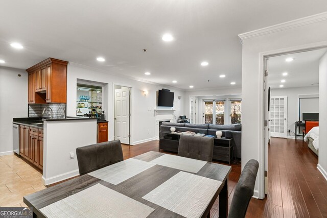 3203 Lenox Rd NE Unit 1, Atlanta, GA 30324 - dining space with baseboards, light wood-style flooring, a fireplace, recessed lighting, and ornamental molding