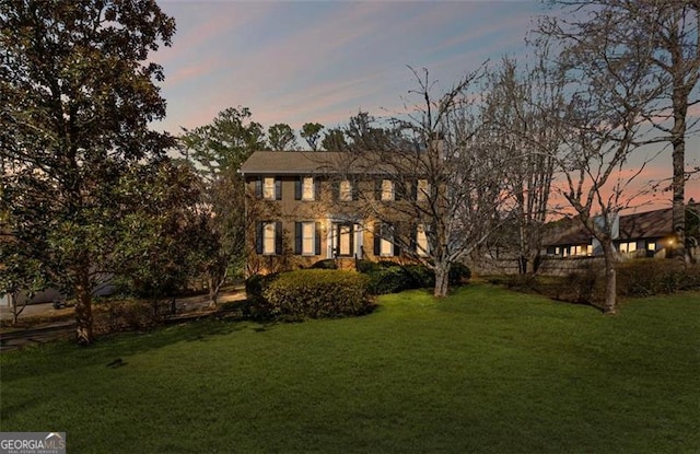 colonial house featuring a front lawn